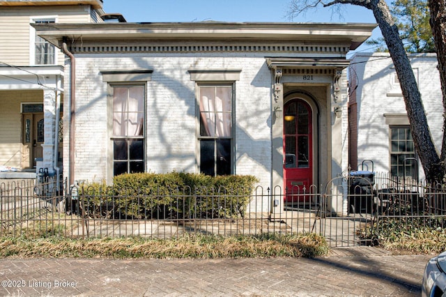 property entrance with fence and brick siding