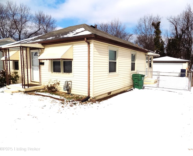 view of front of property with an outbuilding, a gate, a detached garage, and fence