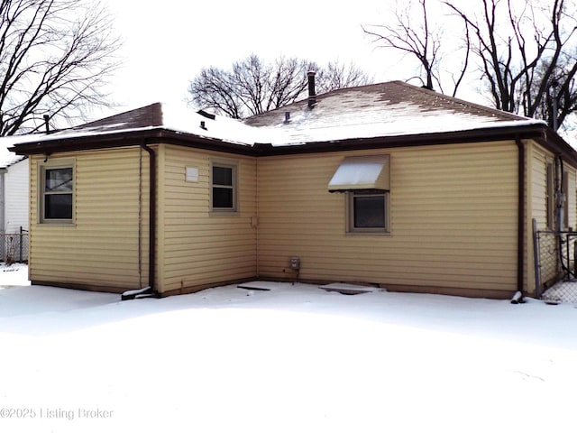 view of snow covered rear of property