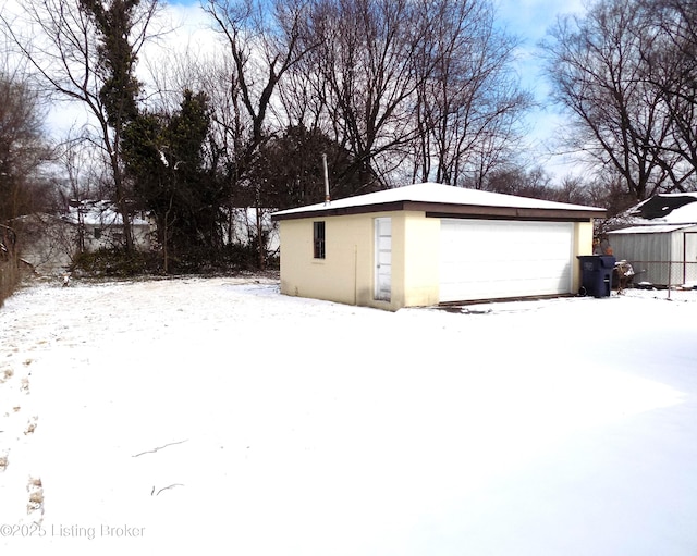 snow covered garage with a garage