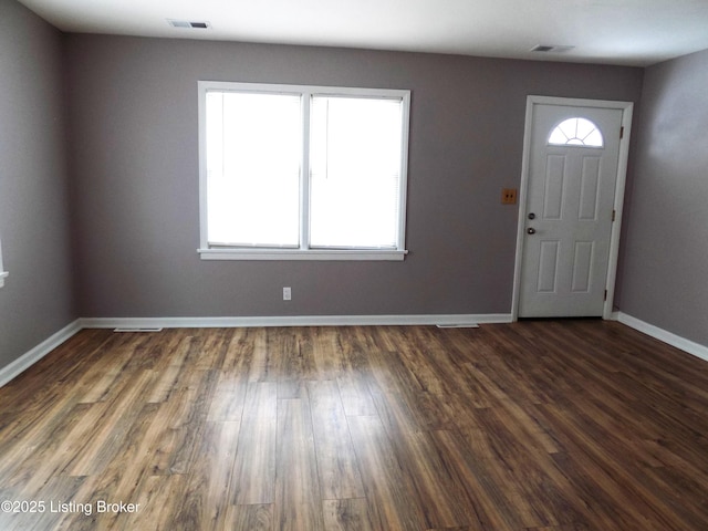 foyer entrance featuring baseboards, visible vents, and a wealth of natural light