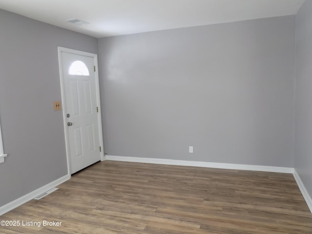 entryway featuring visible vents, baseboards, and wood finished floors