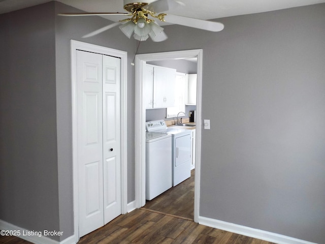 interior space featuring washer and dryer, dark wood finished floors, a sink, and baseboards