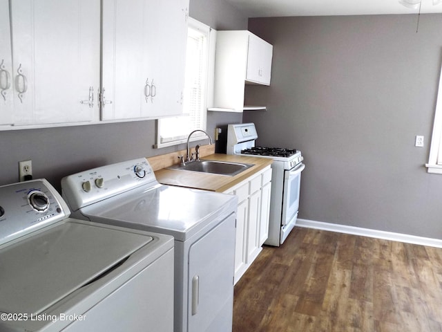 washroom with dark wood-type flooring, a sink, laundry area, independent washer and dryer, and baseboards