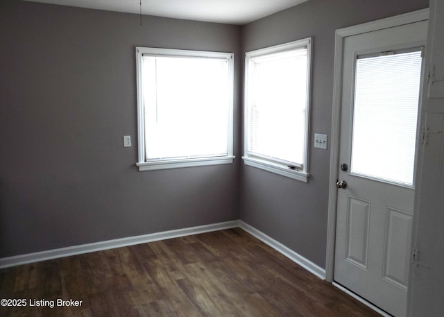 doorway with dark wood-style floors and baseboards