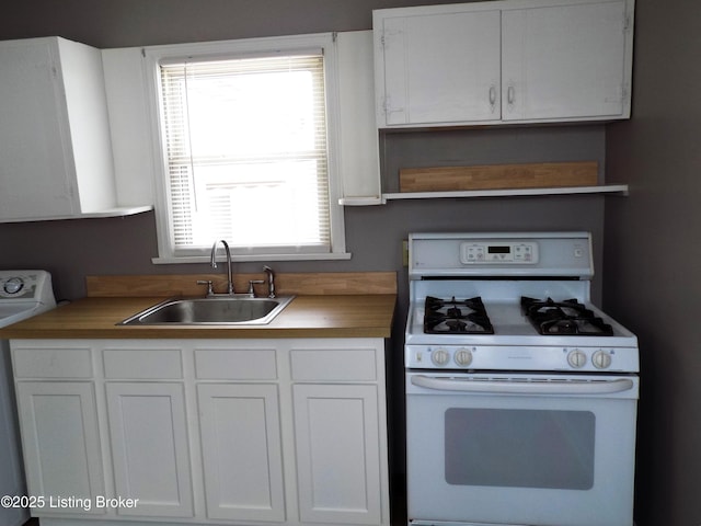 kitchen with open shelves, washer / clothes dryer, white cabinetry, white range with gas cooktop, and a sink