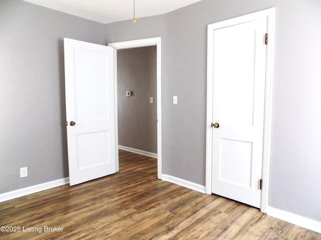 unfurnished bedroom featuring baseboards and wood finished floors