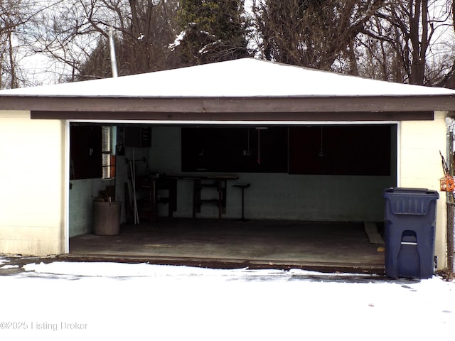 snow covered garage with a garage