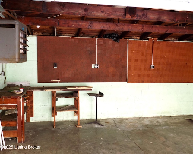 basement with a workshop area and concrete block wall