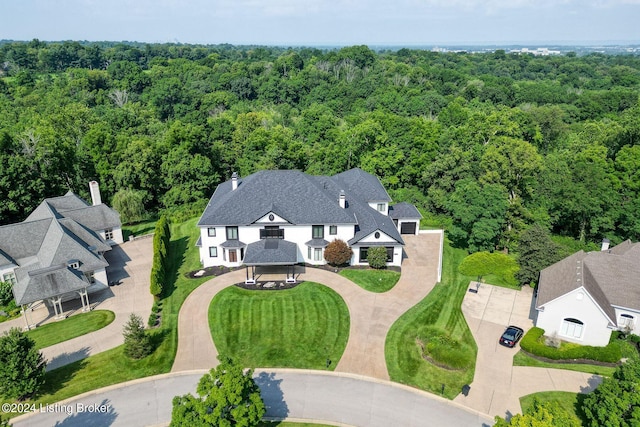 bird's eye view with a wooded view