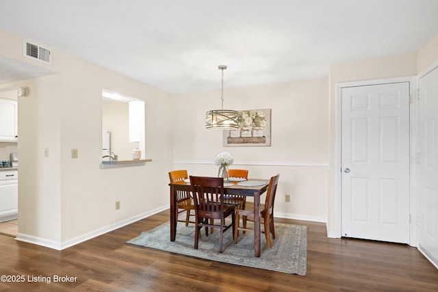 dining space with dark wood-style flooring, visible vents, and baseboards