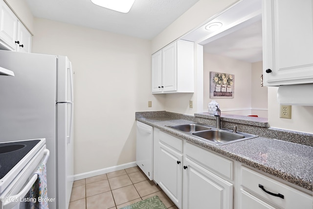 kitchen with light tile patterned flooring, white appliances, a sink, white cabinetry, and dark countertops