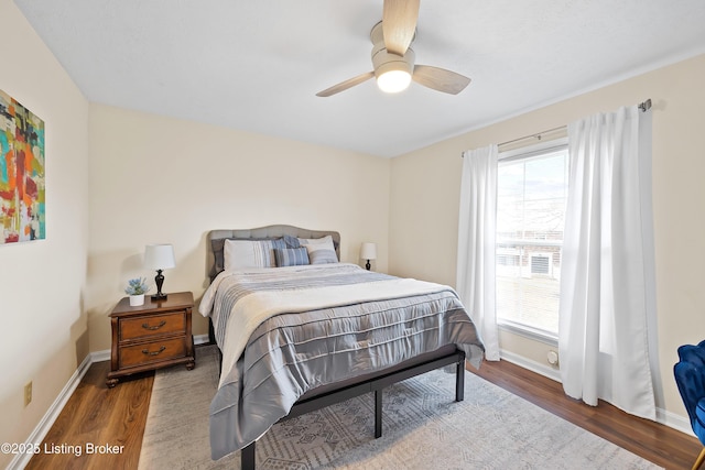 bedroom with a ceiling fan, baseboards, and wood finished floors