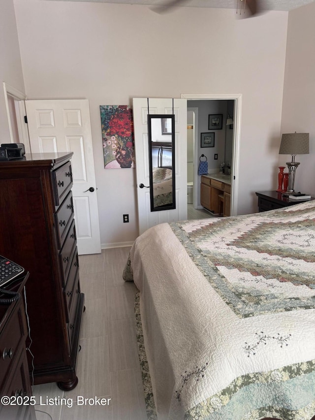 bedroom featuring baseboards and ensuite bath