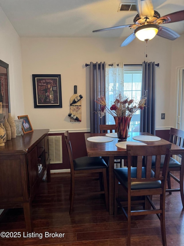dining space featuring a ceiling fan, visible vents, and dark wood-type flooring