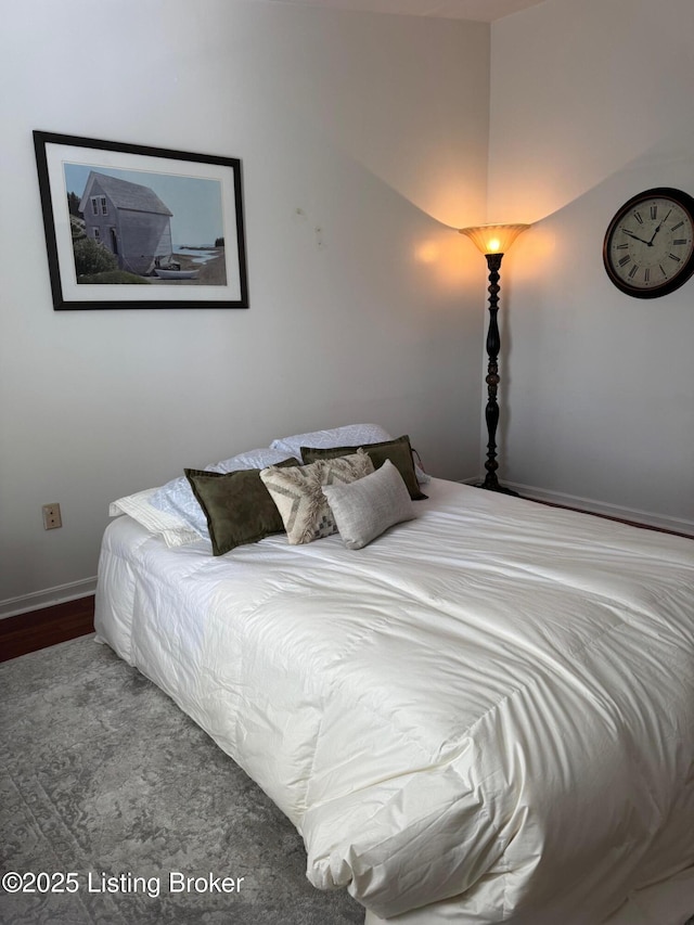 bedroom with baseboards and wood finished floors