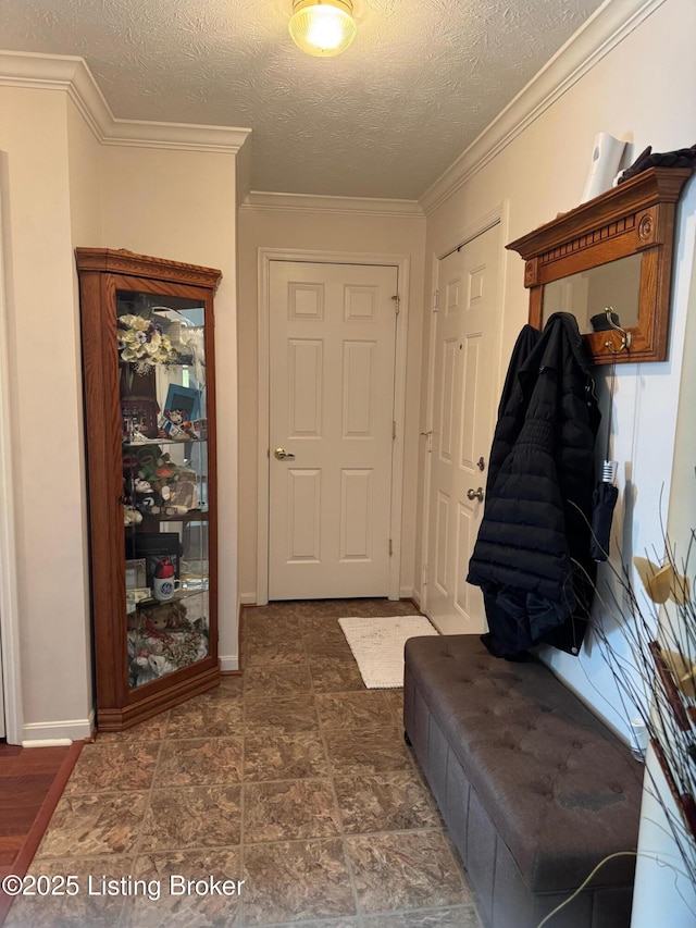 mudroom featuring baseboards, ornamental molding, and a textured ceiling