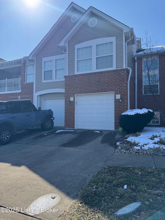 view of front facade featuring driveway, a garage, and brick siding