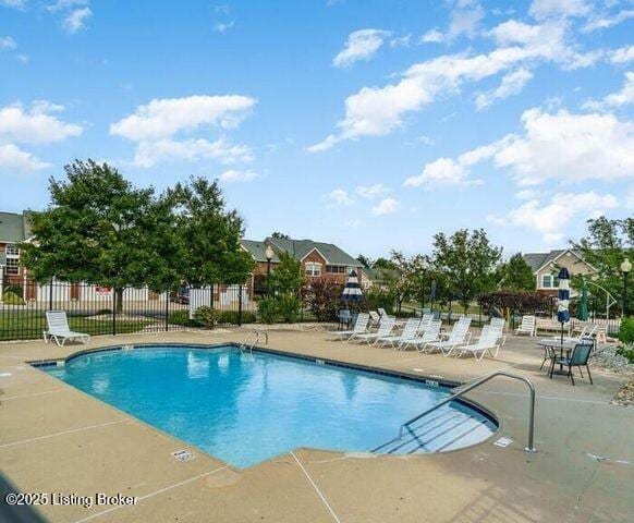 pool with fence and a patio
