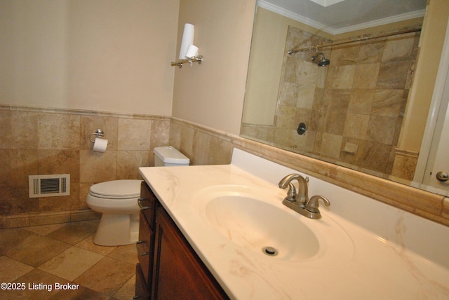 bathroom featuring visible vents, wainscoting, toilet, crown molding, and vanity