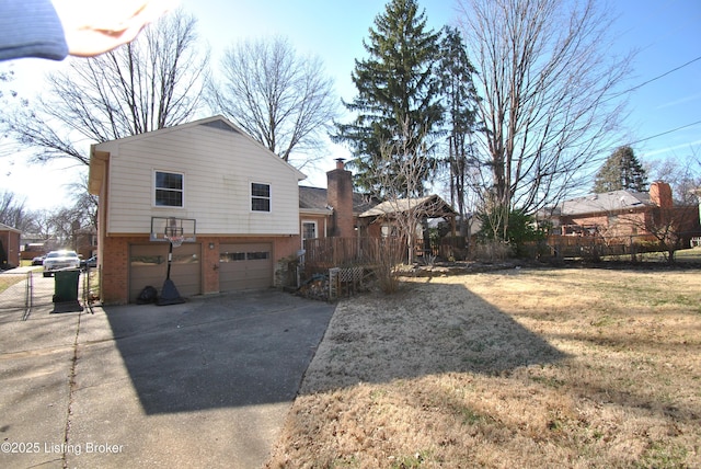 view of side of home with a garage, driveway, fence, and brick siding