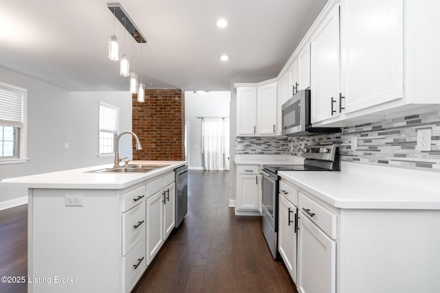 kitchen with tasteful backsplash, dark wood finished floors, stainless steel appliances, and a sink