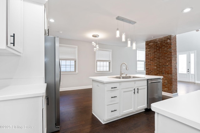 kitchen with appliances with stainless steel finishes, a center island with sink, a sink, and a wealth of natural light