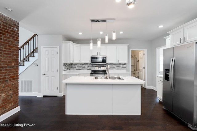 kitchen with visible vents, decorative backsplash, appliances with stainless steel finishes, light countertops, and a sink