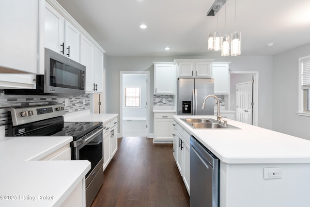 kitchen with dark wood-style floors, stainless steel appliances, a sink, and light countertops