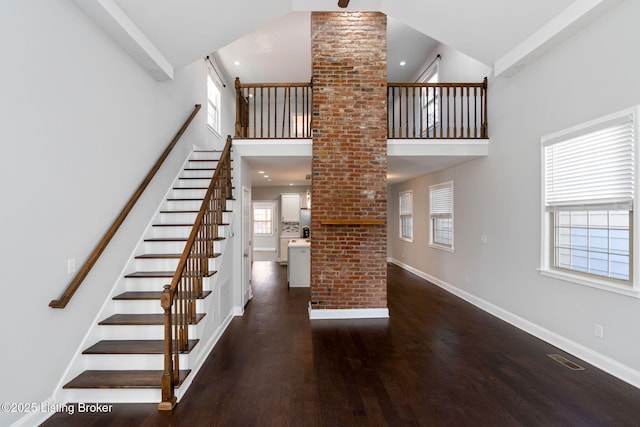 interior space with high vaulted ceiling, baseboards, and wood finished floors