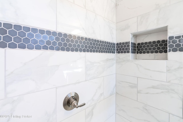 interior details featuring tiled shower