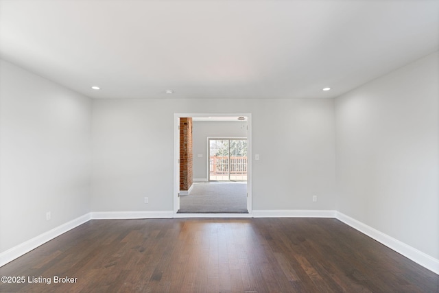 spare room featuring baseboards, dark wood-type flooring, and recessed lighting