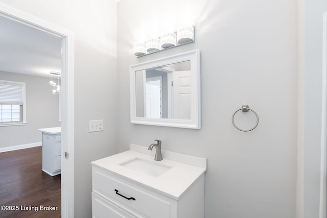 bathroom with wood finished floors, vanity, and baseboards