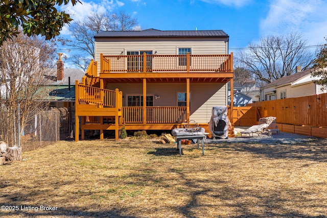 back of house featuring a fenced backyard, metal roof, and a wooden deck