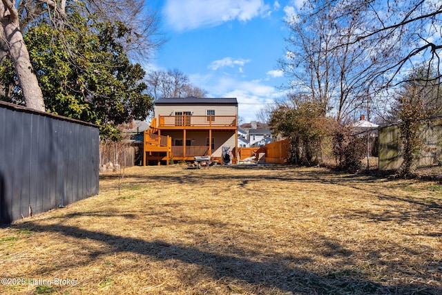 rear view of house featuring a yard, fence, and a deck