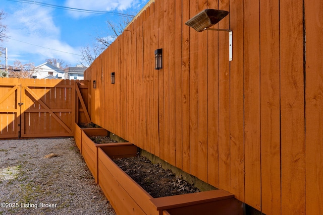 exterior space with a gate, a vegetable garden, and fence