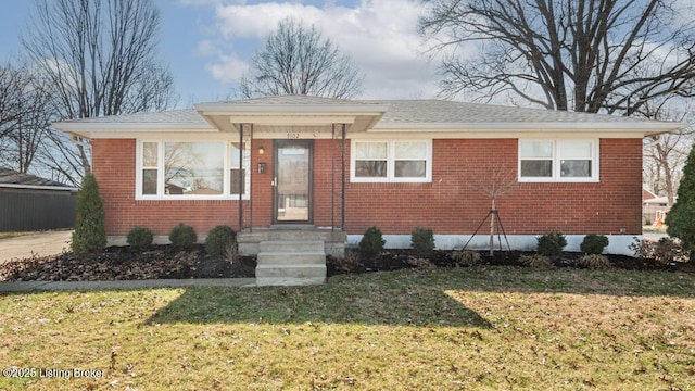 bungalow-style home featuring a front yard, brick siding, and roof with shingles