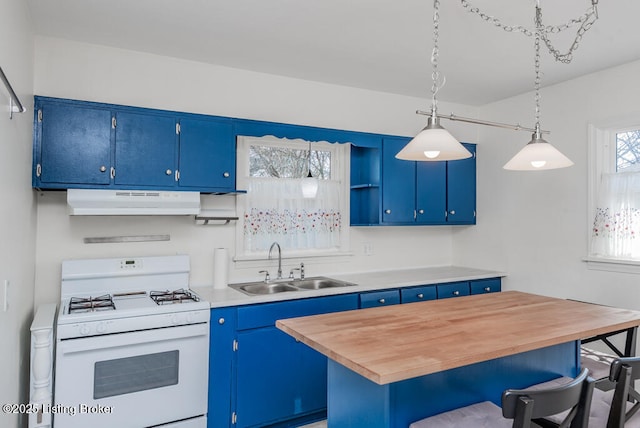 kitchen with white range with gas stovetop, a kitchen breakfast bar, under cabinet range hood, blue cabinetry, and a sink