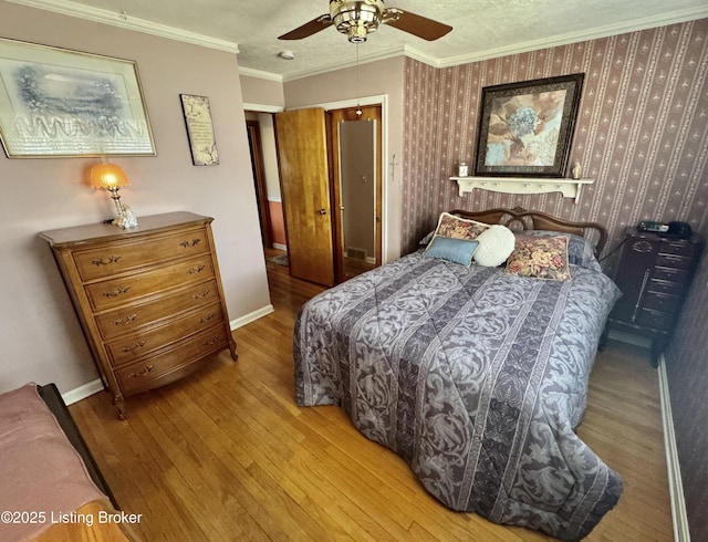 bedroom with wallpapered walls, baseboards, hardwood / wood-style floors, crown molding, and a textured ceiling