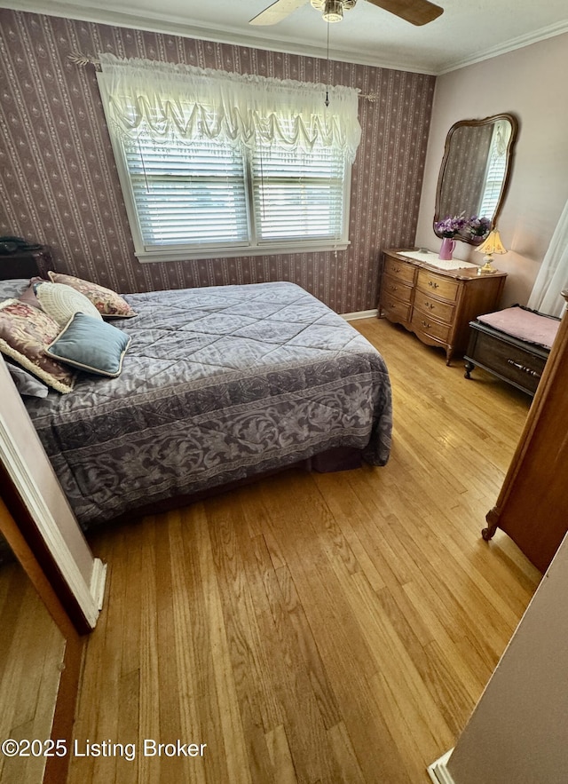 bedroom with ornamental molding, a ceiling fan, wood finished floors, and wallpapered walls