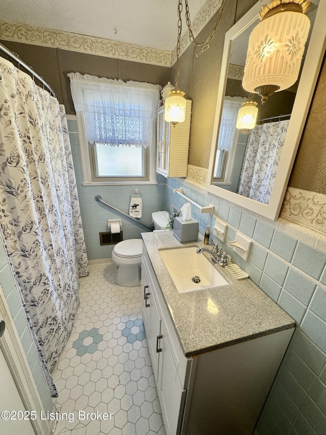 bathroom featuring curtained shower, tile patterned flooring, toilet, vanity, and tile walls