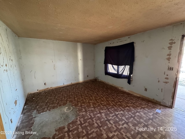 unfurnished room with a textured ceiling