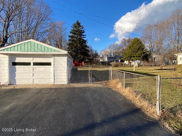 detached garage with aphalt driveway and fence