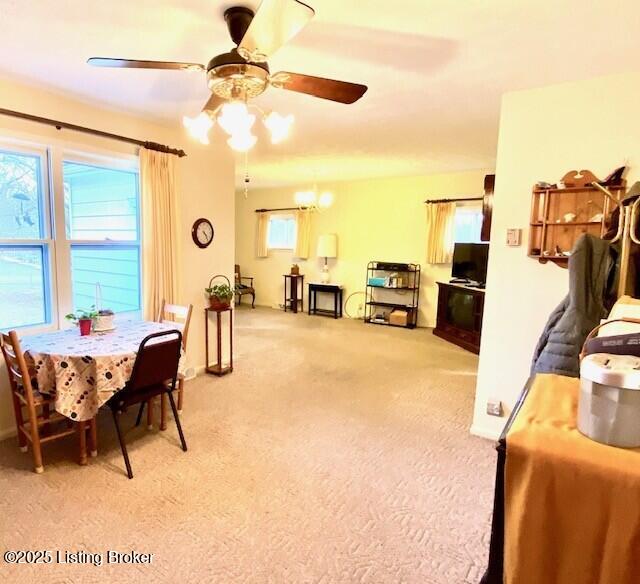 dining area with light carpet, ceiling fan, and baseboards