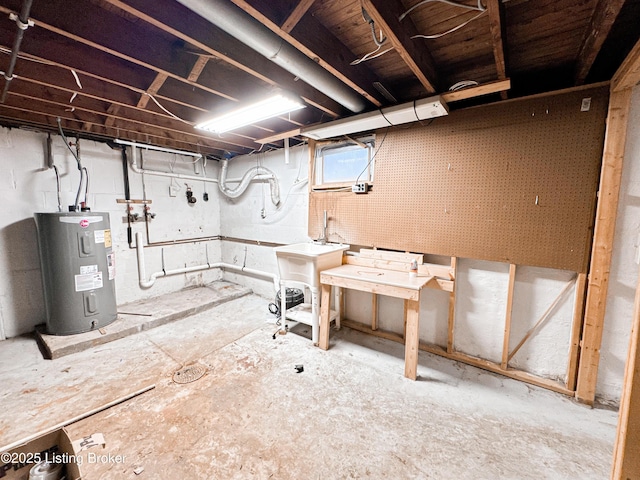 basement featuring a workshop area, a sink, and electric water heater