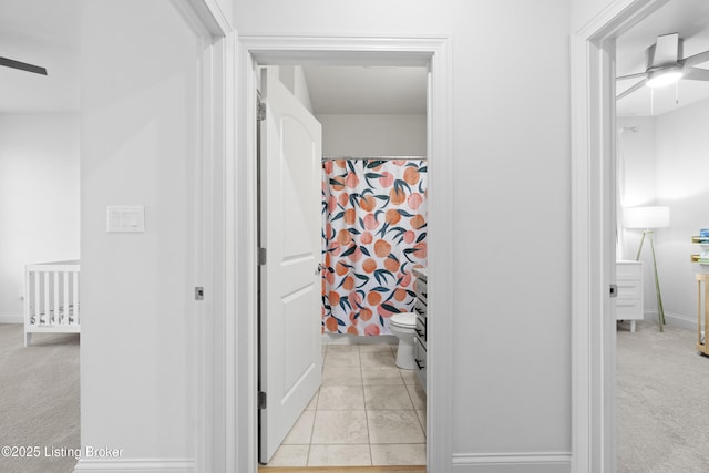 full bathroom with ceiling fan, a shower with shower curtain, toilet, and tile patterned floors