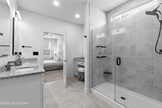 bathroom featuring double vanity, a stall shower, a sink, ensuite bath, and baseboards