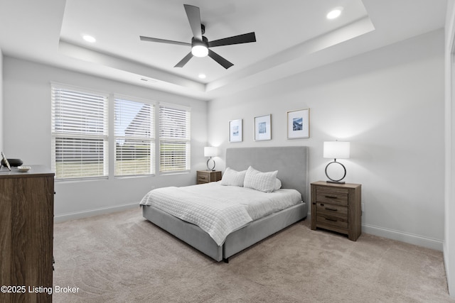 carpeted bedroom featuring a tray ceiling, recessed lighting, and baseboards