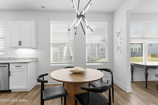 dining space featuring light wood-style floors, baseboards, and visible vents