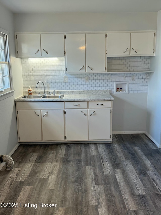 kitchen featuring a sink, decorative backsplash, white cabinets, and dark wood-style flooring